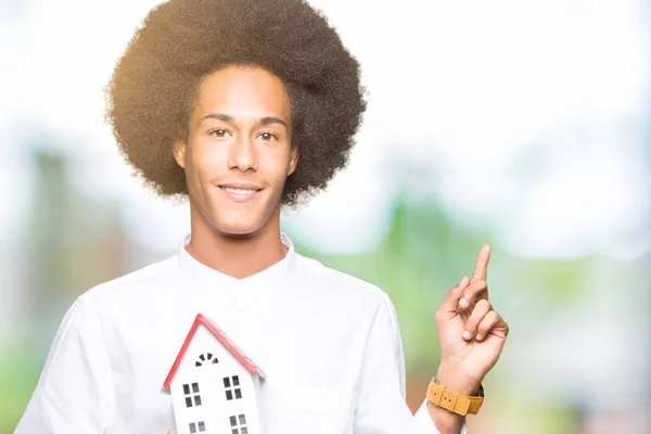アフロ髪側に手や指で非常に幸せな家ポイントを保持している若いアフリカ系アメリカ人 — ストック写真
