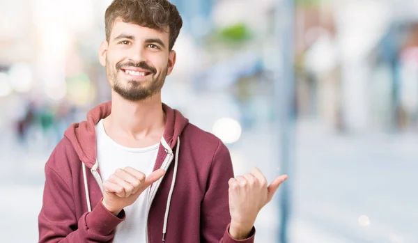 Young Handsome Man Isolated Background Pointing Back Hand Thumbs Smiling — Stock Photo, Image