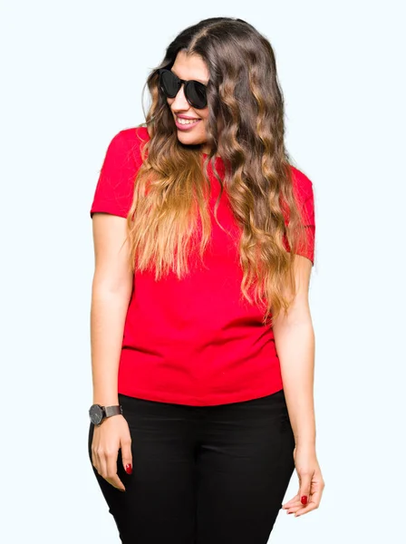 Młoda Piękna Kobieta Ubrana Czerwony Shirt Okulary Przeciwsłoneczne Patrząc Dala — Zdjęcie stockowe