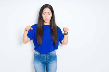 Izole arka plan üzerinde güzel esmer kadın reklam gösteren parmakları ile aşağı işaret, sürpriz yüz ve açık ağız