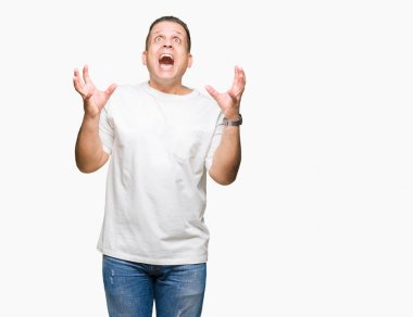 Orta yaş Arap adam wearig izole arka plan kutluyor kızgın ve silah ile başarı için deli üzerinde beyaz t-shirt kaldırdı ve heyecanlı çığlık gözler kapalı. Kazanan kavramı