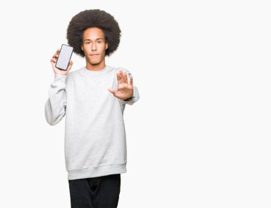 Smartphone perde ile gösterilen afro saçlı genç Afro-Amerikan adam dur işareti ile ciddi ve kendine güvenen ifade, savunma hareketi yaparken el açmak