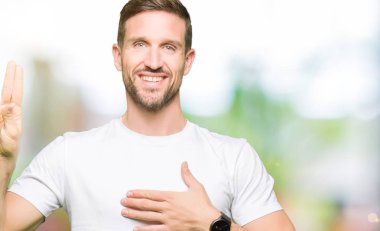 Rahat beyaz t-shirt giyen yakışıklı adam göğsüne ve parmaklara el ile küfür, sadakat vaat yemini yapma