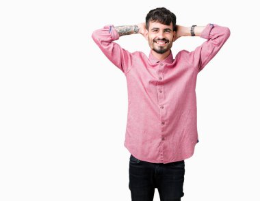 Pembe gömlek izole üzerinde giyen genç yakışıklı adam arka plan dinlenirken ve germe kollar ve eller baş ve boyun arkasında ile mutlu gülümseyerek
