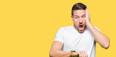 Casual beyaz t-shirt arıyorsunuz seyretmek zaman endişeli, geç korkuyor giyen yakışıklı adam