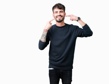 Tecrit edilmiş, güler yüzlü, kendine güvenen, parmaklarını, dişlerini ve ağzını gösteren genç yakışıklı bir adam. Sağlık kavramı.