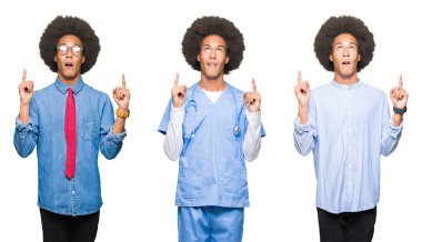 Beyaz izole arka plan üzerinde afro saç ile genç adam kolaj hayret ve görünümlü ve parmaklar ve yükseltilmiş kollar ile işaret şaşırdı.