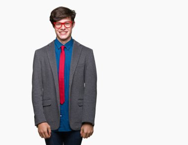 Genç yakışıklı iş adamı yüz üzerinde mutlu ve serin bir gülümseme ile izole arka plan üzerinde kırmızı gözlük giyiyor. Şanslı kişi.