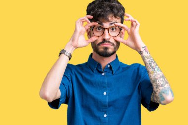 Parmaklarıyla, Uykulu ve sabah yorgunluk için yorgun gözlerini açmaya çalışırken izole arka plan üzerinde gözlük takan genç yakışıklı adam