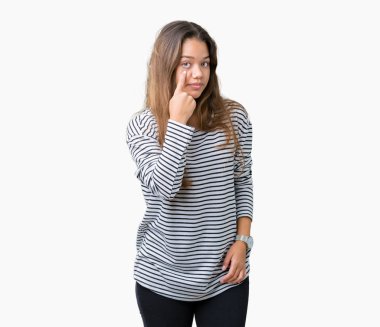 İzole arka plan üzerinde çizgili kazak giyen genç güzel esmer kadın seni jest izlerken göz Işaret, şüpheli ifade