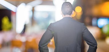 Genç Hıristiyan rahip izole arka plan ayakta geriye doğru uzakta silah ile vücut üzerinde seyir üzerinde