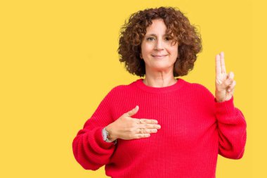 Güzel orta ager üst düzey kadın kırmızı kış kazak izole üzerinde arka plan Swearing göğüs ve bir sadakat sözü yemin yapma parmaklar, el ile