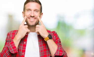 Rahat gömlek giyen yakışıklı adam açık ağız ile gülümseyen, parmaklar işaret ve neşeli gülümseme zorlayarak