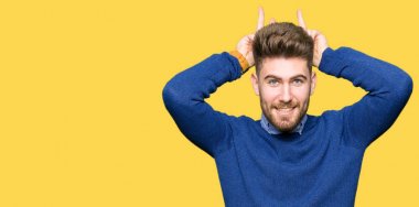 Genç yakışıklı bussines komik poz ve baş parmak ile deli adam neşeli gülümseyen tavşan kulakları