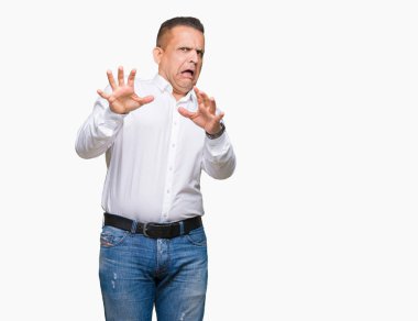 Şokta bağırarak orta yaş Arap zarif adam izole arka plan korkuyor ve korku ifade dur hareketi el ile ile çok korkmuş. Panik kavramı.