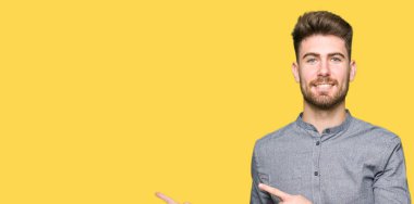 Gülümseyen ve iki elleri ve parmakları ile tarafına işaret kamera bakarak genç yakışıklı iş casual adam.