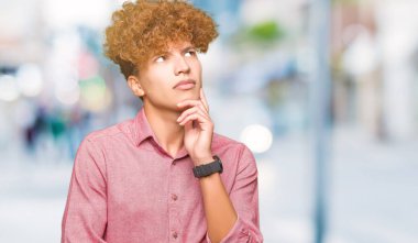 Çene düşünme hakkında soru, dalgın ifade üzerine el ile afro saçlı genç yakışıklı iş adamı. Düşünceli yüzüyle gülümsüyor. Şüphe kavramı.