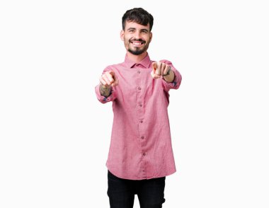 Pembe gömlek izole üzerinde giyen genç yakışıklı adam arka plan size işaret ve parmaklar, kamerayla olumlu ve neşeli gülümseyen