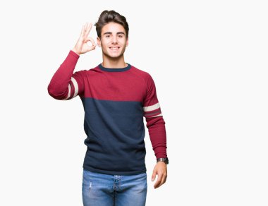 Gülümseyen izole arka plan üzerinde genç yakışıklı adam el ve parmaklar ok işaretiyle yapıyor olumlu. Başarılı ifade.