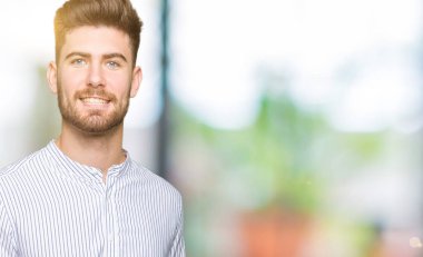 Genç yakışıklı gösteren palm el ve yukarıya, mutlu ve neşeli gülümseyen baş parmakları Tamam jest yapıyor adam