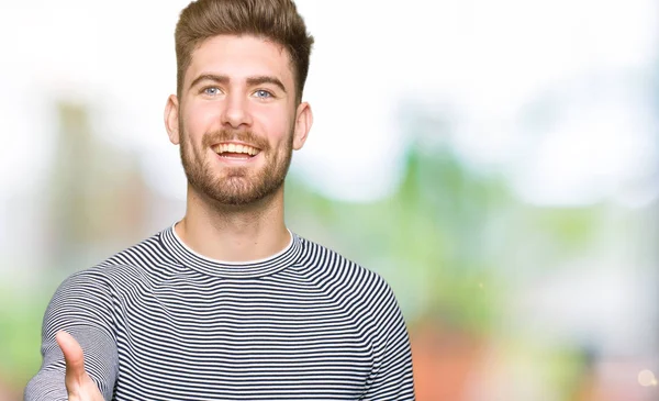 Joven Hombre Guapo Con Rayas Suéter Sonriente Amistoso Ofreciendo Apretón —  Fotos de Stock