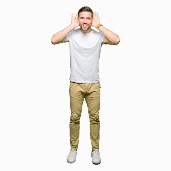 Hombre Guapo Usando Una Camiseta Blanca Casual Tratando Escuchar Ambos —  Fotos de Stock