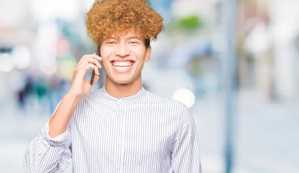 若いハンサムな男は幸せそうな顔の立っていると電話で話していると自信を持って歯を見せて笑顔を浮かべて — ストック写真