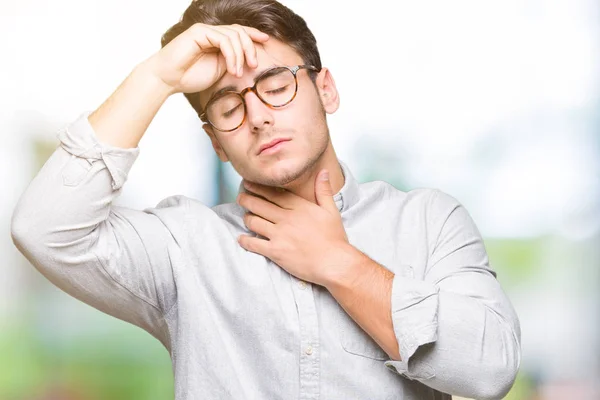 Young handsome man wearing glasses over isolated background Touching forehead for illness and fever, flu and cold, virus sick