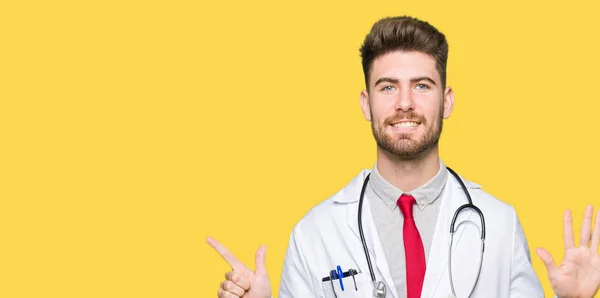 Gösterilen Parmakları Ile Işaret Tıbbi Ceket Giyen Genç Yakışıklı Doktor — Stok fotoğraf