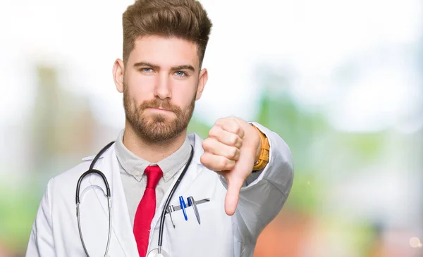 Młody Przystojny Lekarz Mężczyzna Noszenie Płaszcz Medyczny Szuka Nieszczęśliwy Zły — Zdjęcie stockowe