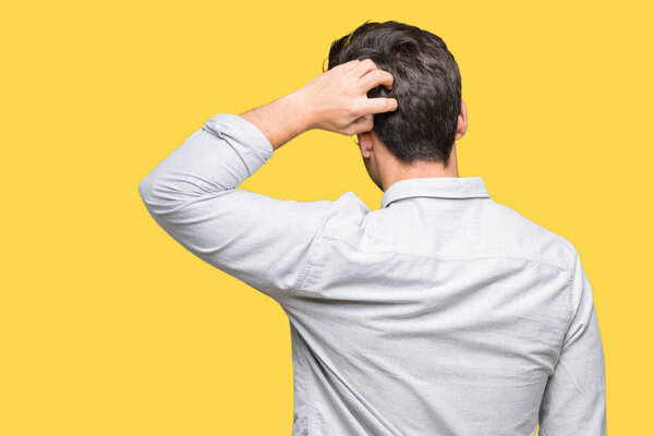 Молодой красивый мужчина в очках на изолированном заднем плане думает о сомнении с рукой на голове
