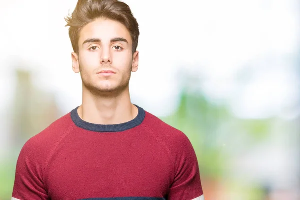 Young handsome man over isolated background Relaxed with serious expression on face. Simple and natural looking at the camera.