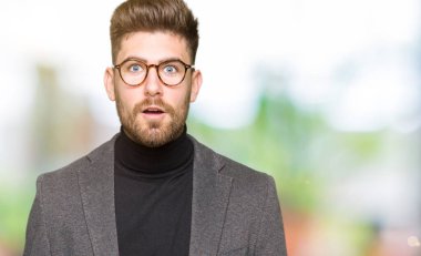 Korkuyor ve şok sürpriz ifade, korku ve heyecan yüz ile gözlüklü genç yakışıklı iş adamı.
