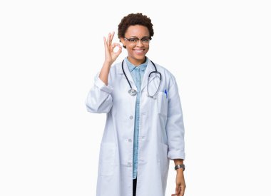 İzole arka plan el ve parmaklar ok işaretiyle yapıyor olumlu gülümseyen üzerinde tıbbi ceket giyen genç Afro-Amerikan doktor kadın. Başarılı ifade.