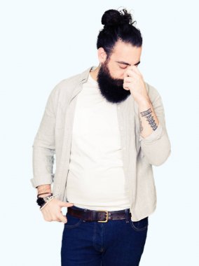 Uzun saç, sakal ve burun ve göz yorgunluğu ve baş ağrısı duygu sürtünme yorgun küpe olan genç adam. Stres ve hayal kırıklığı kavramı.