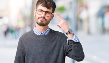 Genç yakışıklı zeki adam gözlük izole üzerinde çekim ve öldürmek kendini el ve parmaklara baş, intihar jest işaret arka plan.