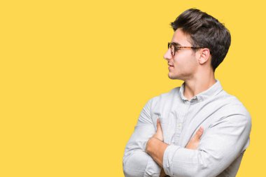 İkna ve kendine güvenen tarafına silahlarla seyir gülümseyen izole arka plan üzerinde gözlük takan genç yakışıklı adam geçti