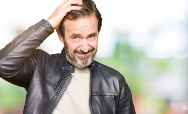 Siyah deri ceketli orta yaş yakışıklı adam yanıltır ve soru hakkında merak ediyorum. Şüphe, kafasına el ile düşünme ile belirsiz. Dalgın kavramı.