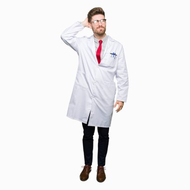 Genç yakışıklı bilim adam gözlük yanıltır ve soru hakkında merak ediyorum. Şüphe, kafasına el ile düşünme ile belirsiz. Dalgın kavramı.