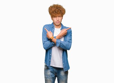 Afro saçlı kot ceket giyen genç yakışıklı adam işaret parmaklarıyla, farklı yönde iki tarafa da katılmıyorum