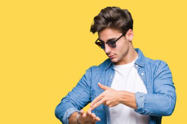 Yakışıklı delikanlı acele işaretleme izlemek için zaman, sabırsızlık, üzgün ve kızgın son tarih gecikme için izole arka plan üzerinde güneş gözlüğü takıyor