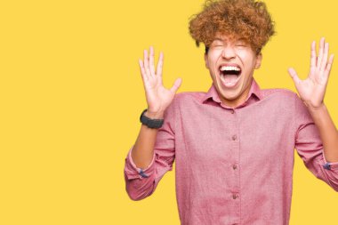 Afro saç ile genç yakışıklı iş adamı deli ve silah ile başarı için deli kutluyor ve kapalı gözleri heyecanlı çığlık kaldırdı. Kazanan kavramı