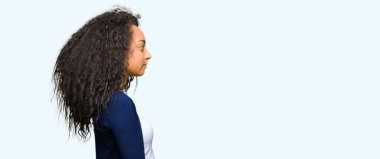 Genç güzel kız tarafına, seyir kıvırcık saçlı dinlenmek doğal yüz emin gülümseme ile pozuyla profil.