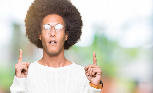 アフロ髪眼鏡をかけてびっくりし 驚き見て 指で指して 腕を上げた若いアフリカ系アメリカ人 — ストック写真