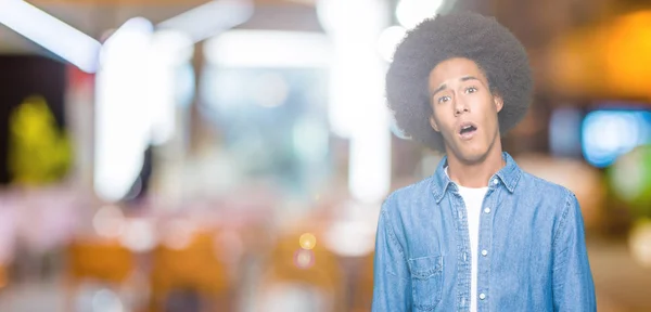 アフロヘアを持つ若いアフリカ系アメリカ人男性ショック顔で 懐疑的で皮肉に見え 口を開いて驚いた — ストック写真