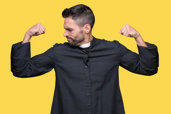 Young Christian priest over isolated background showing arms muscles smiling proud. Fitness concept.