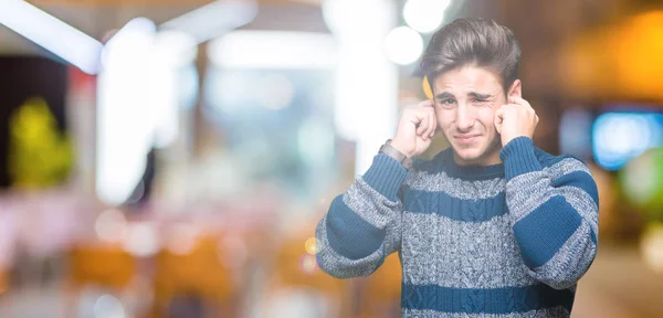 騒々しい音楽のノイズの腹式指で耳を覆う孤立の背景の上の若いハンサムな男 聴覚障害者の概念 — ストック写真