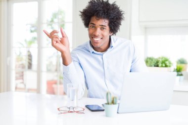 Afrika kökenli Amerikalı iş adamı dizüstü el ve parmak ile tarafına işaret çok mutlu kullanarak çalışma