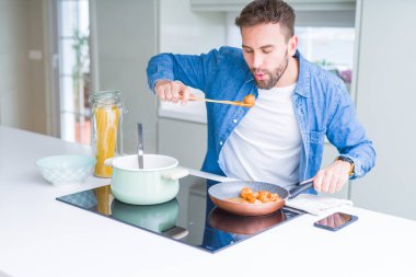Evde makarna pişiren yakışıklı adam.