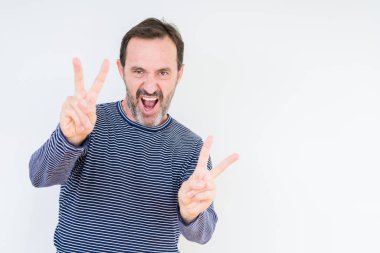 Zafer işareti yapıyor parmak gösterilen kamera seyir gülümseyen izole arka plan üzerinde yakışıklı komuta sizde. İki numaralı.